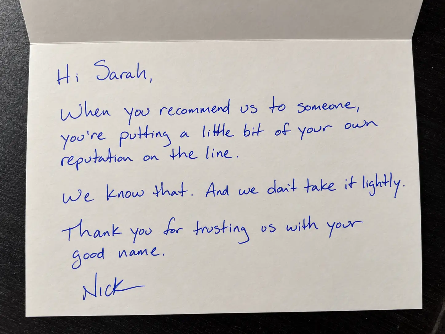 Inside of a folded card with a handwritten message in blue ink that begins “Hi Sarah,” and thanks a client for a referral.